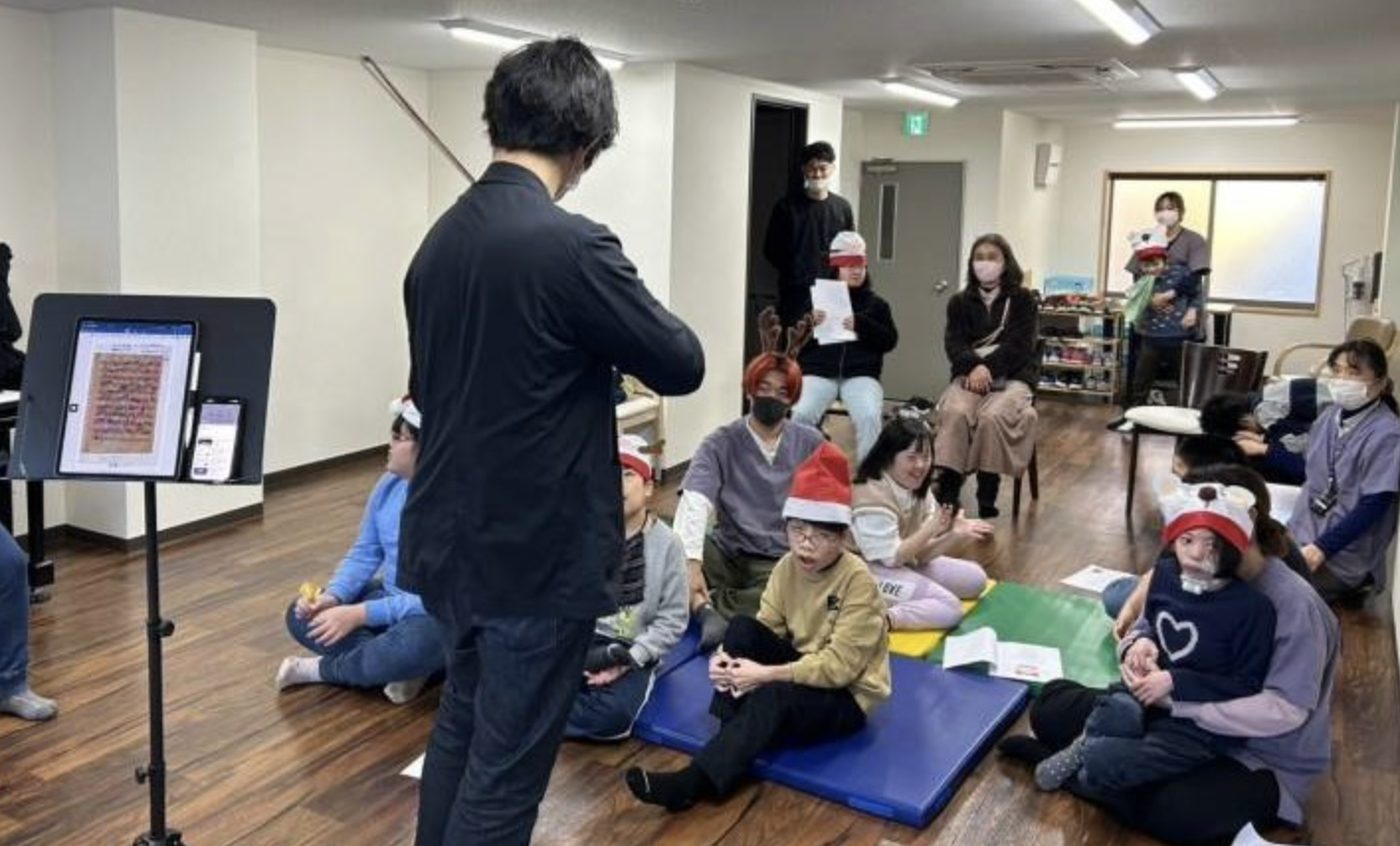 療育室でプロの演奏家の生演奏を、子どもたちがくつろいだ姿勢で聴いている様子